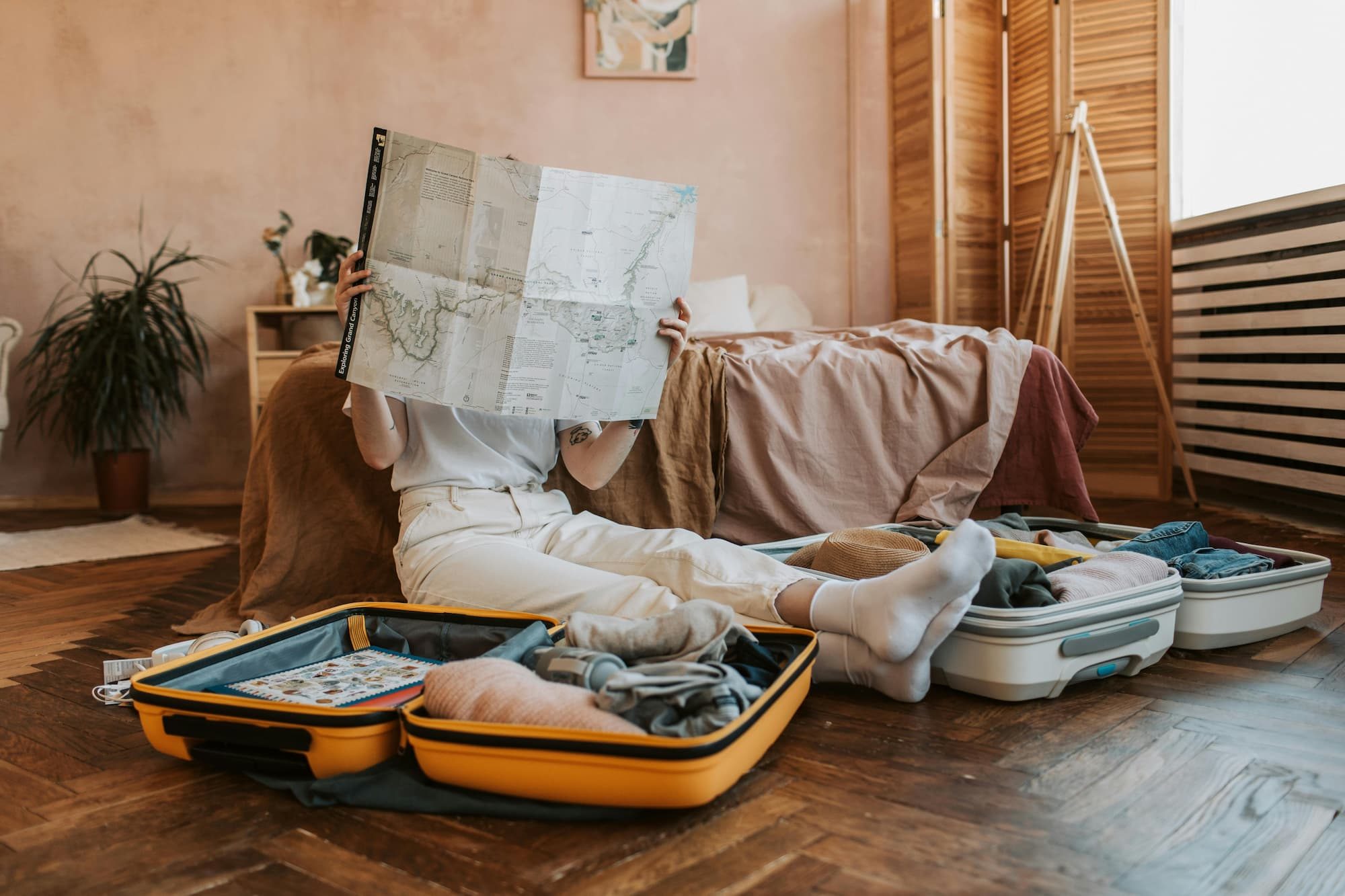 two open suitcases and a person looking at a map