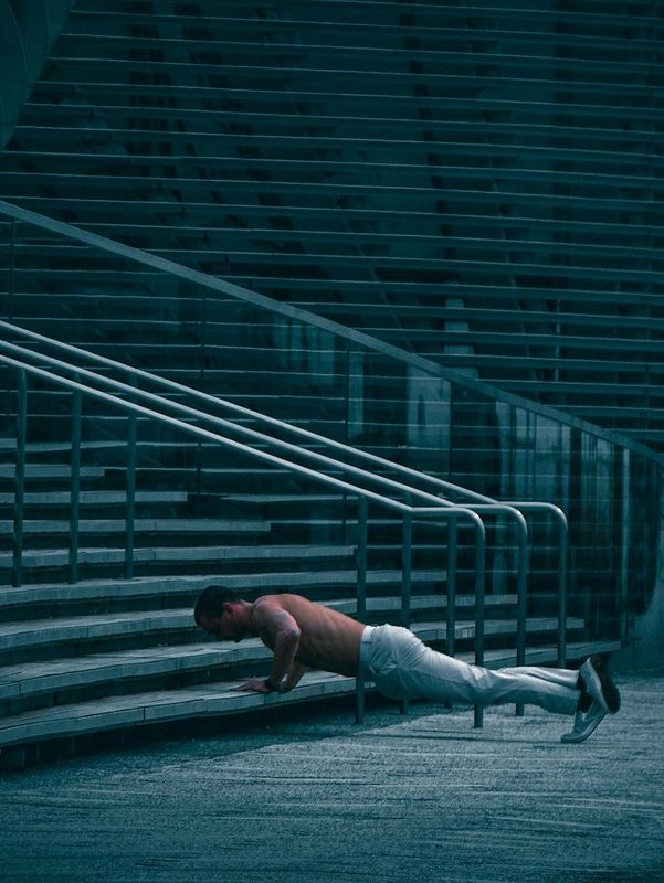 man doing calisthenic incline push up on stairs exercise dark at night evening