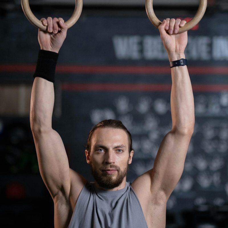man hanging from gymnastic rings dead hang exercise