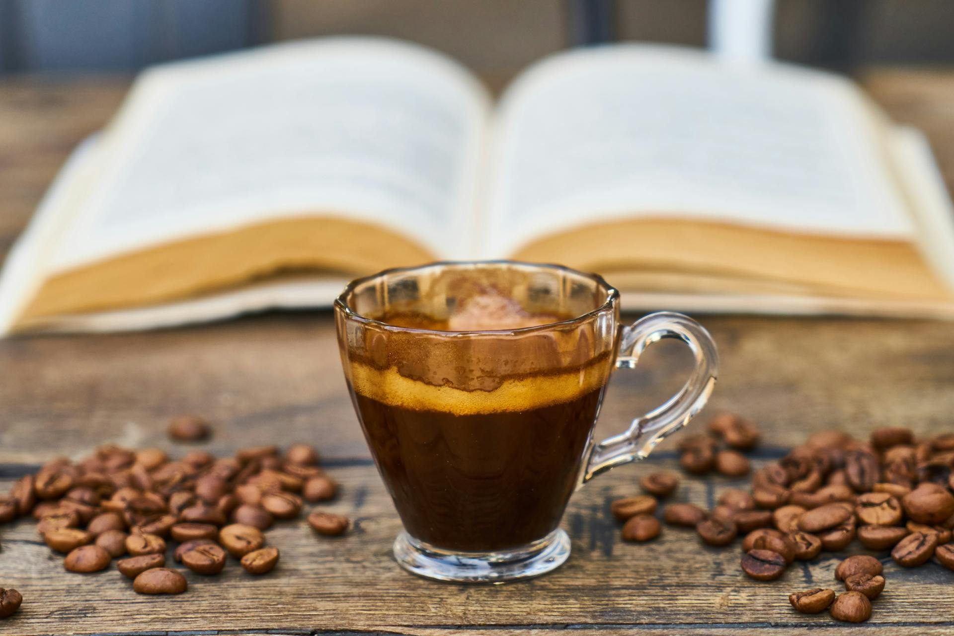 Espresso cup with a book and coffee beans