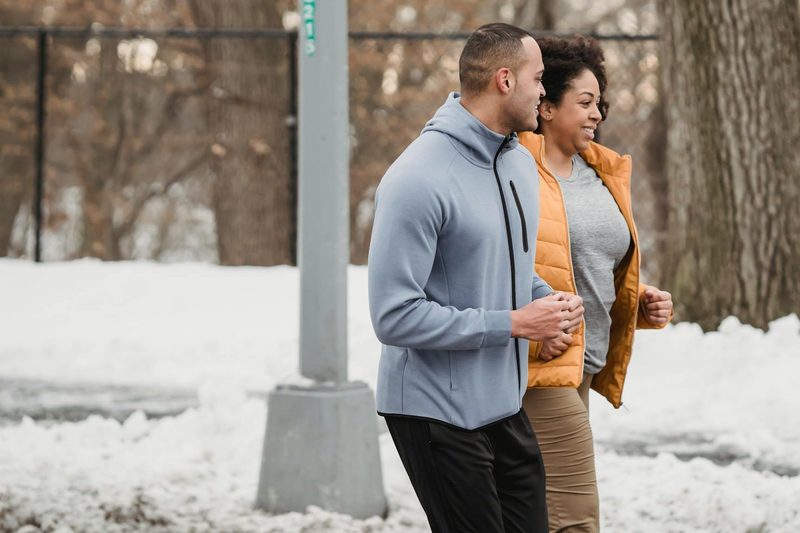 man and woman running outdoors in cold working ou