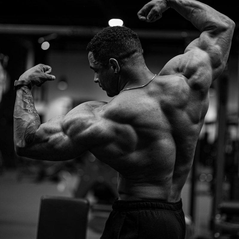 flexing muscular shirtless man black and white image