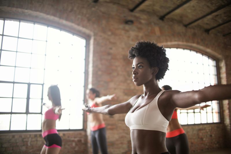 women in gym doing arm circles or arm exercises stretches