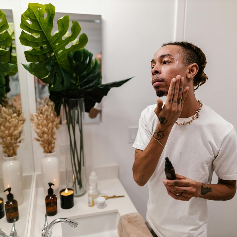 a man applying skincaare products in mirror