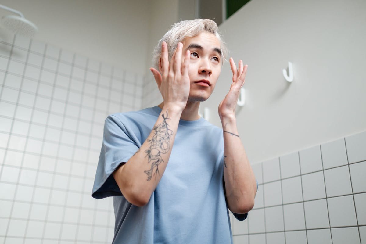 man doing skincare in the mirror