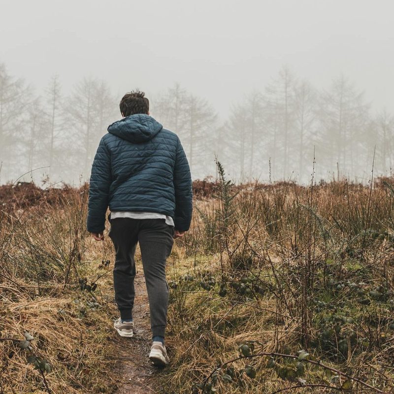 Man walking outside with coat in nature