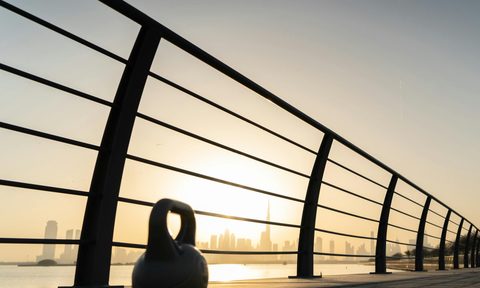 kettlebell at sunset next to fence workout
