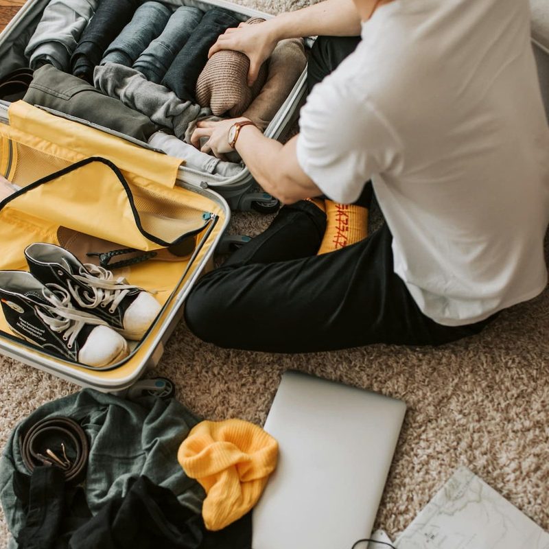 A man packing clothes in his suitcase