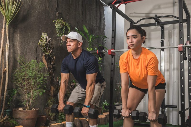 dumbbell Romanian deadlift or RDL man and woman working out in gym with dumbbell