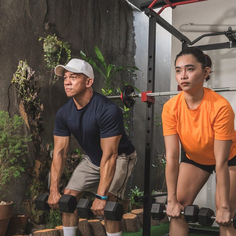 Dumbbell Romanian deadlift or RDL man and woman working out in gym with dumbbell