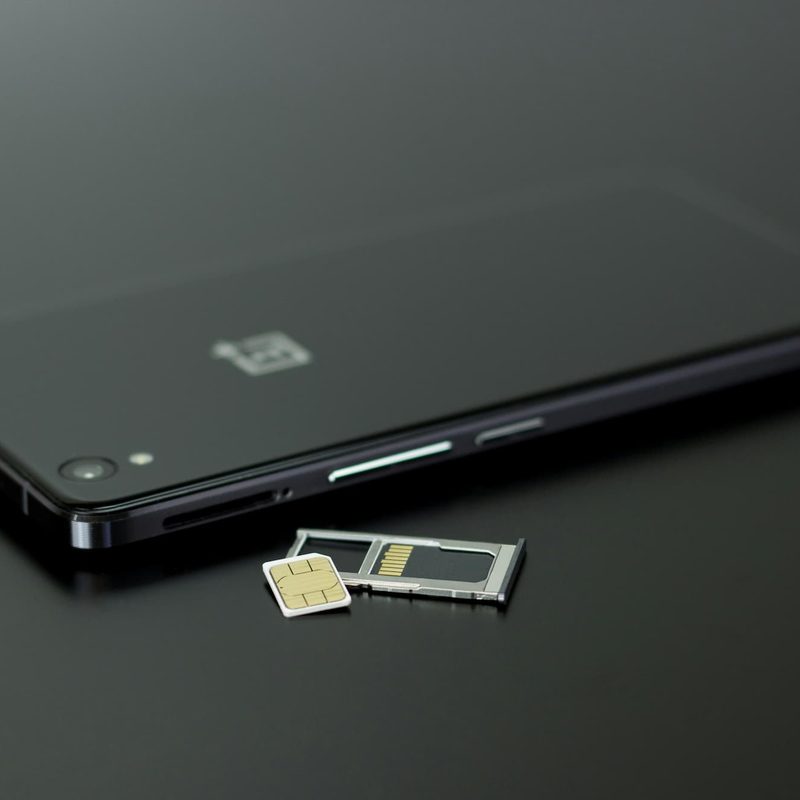 black smartphone next to a sim card