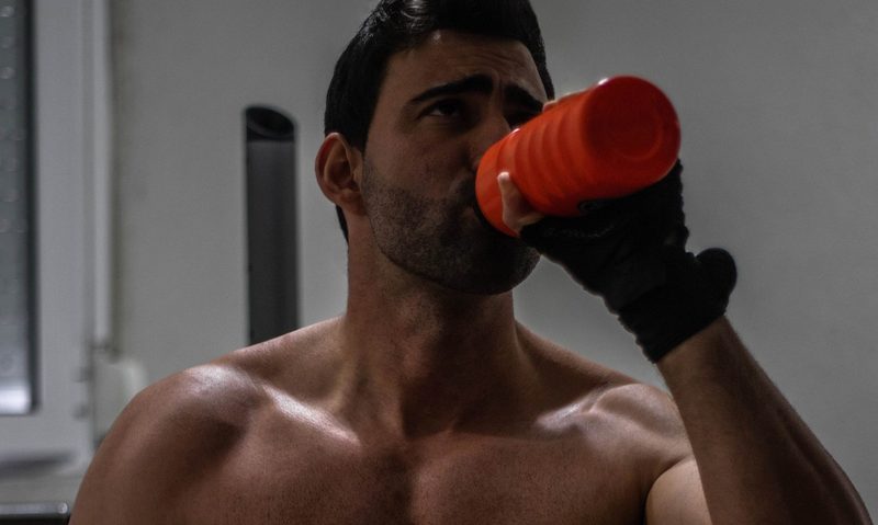 Shirtless man drinking protein shake drink muscle