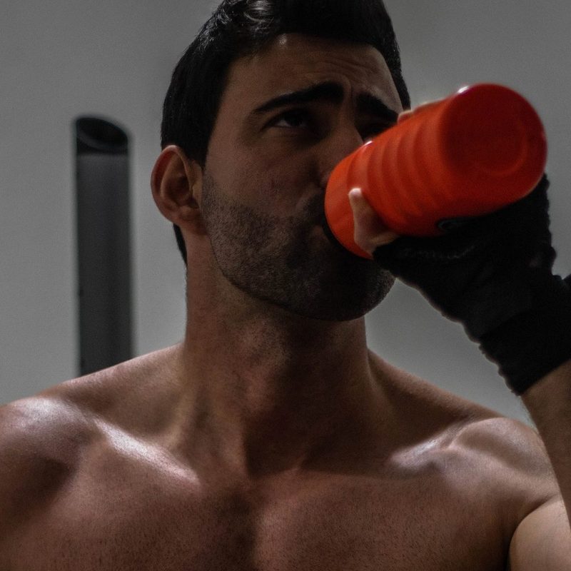 Shirtless man drinking protein shake drink muscle