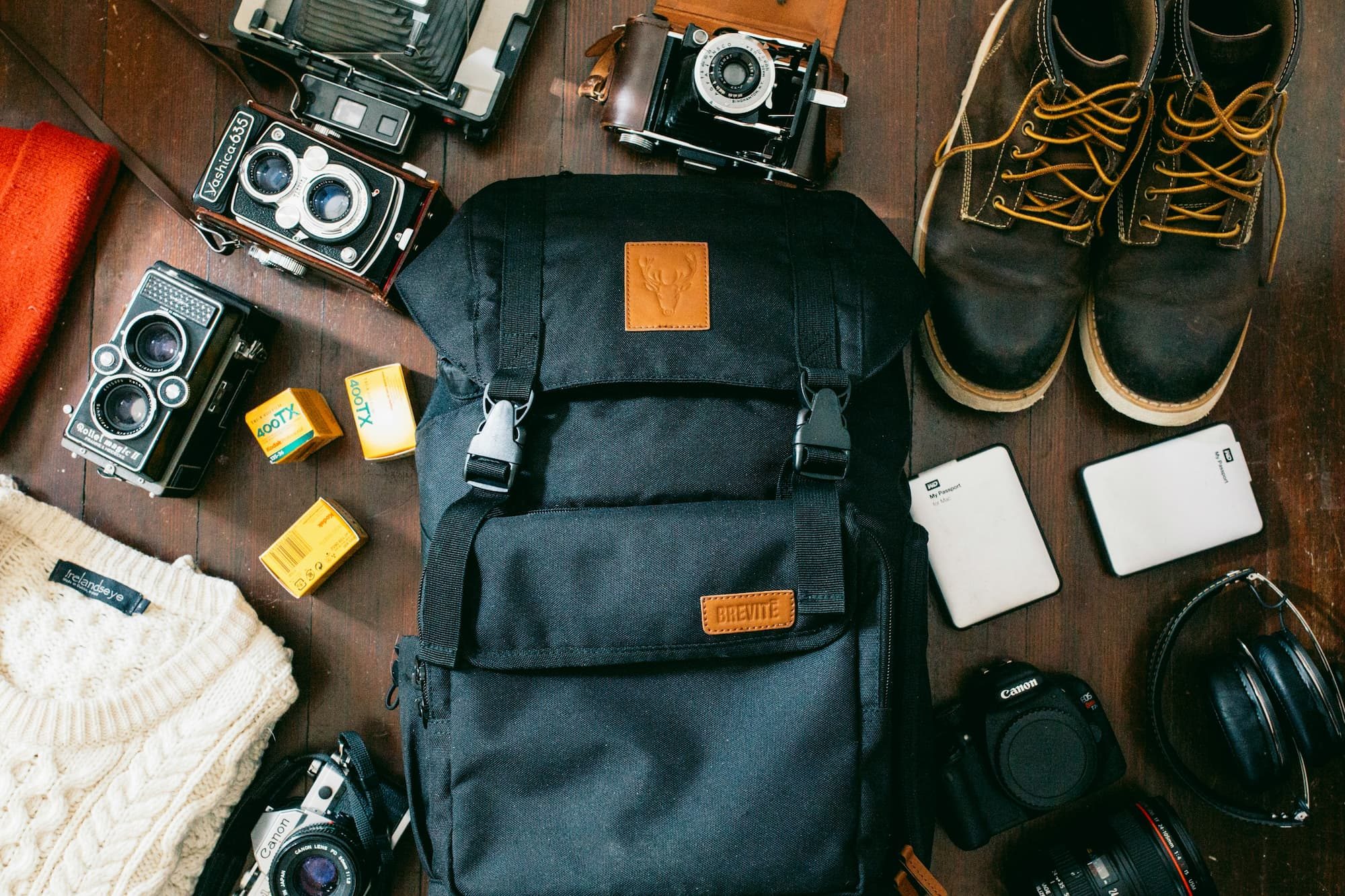 camera and accessories scattered around backpack