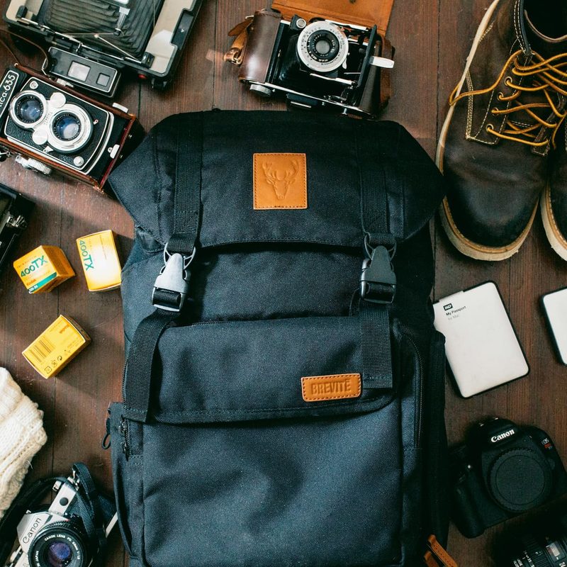 Camera and accessories scattered around backpack