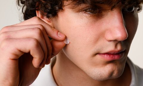 young man applying pimple patch