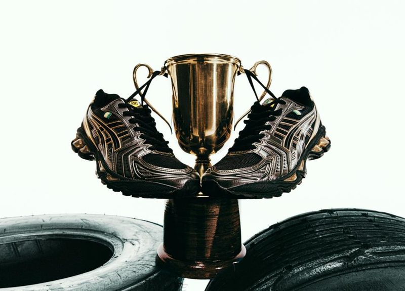 black and gold sneaker hanging off trophy over tires