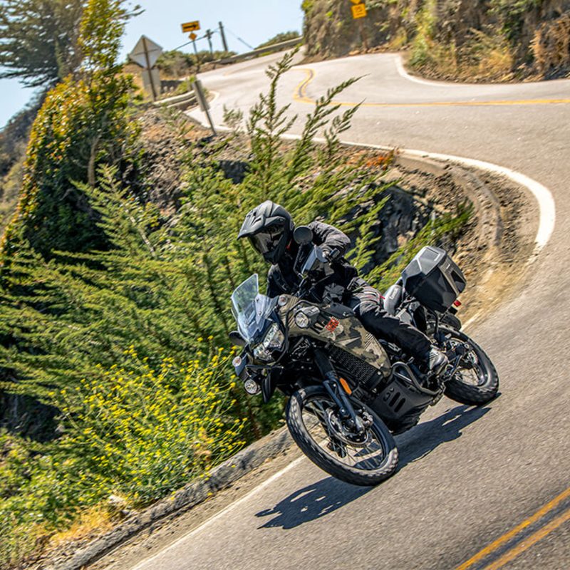 One rider on a 2025 Kawasaki KLR 650 Adventure ABS desecending a winding mountain road.