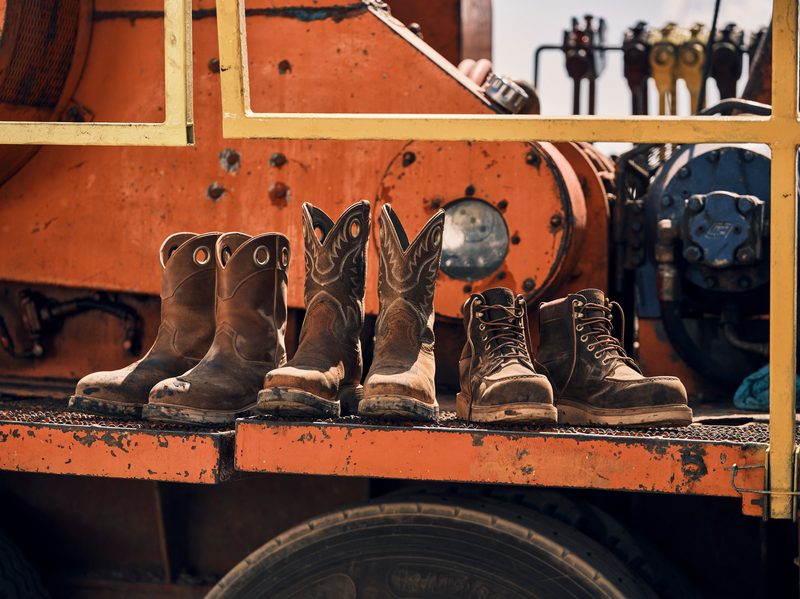 lineup of Tecovas new work boots on top of construction truck