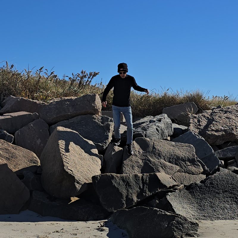 A man hopping on boulders at the shore in A historic building hosting local businesses in downtown Westerly, RI