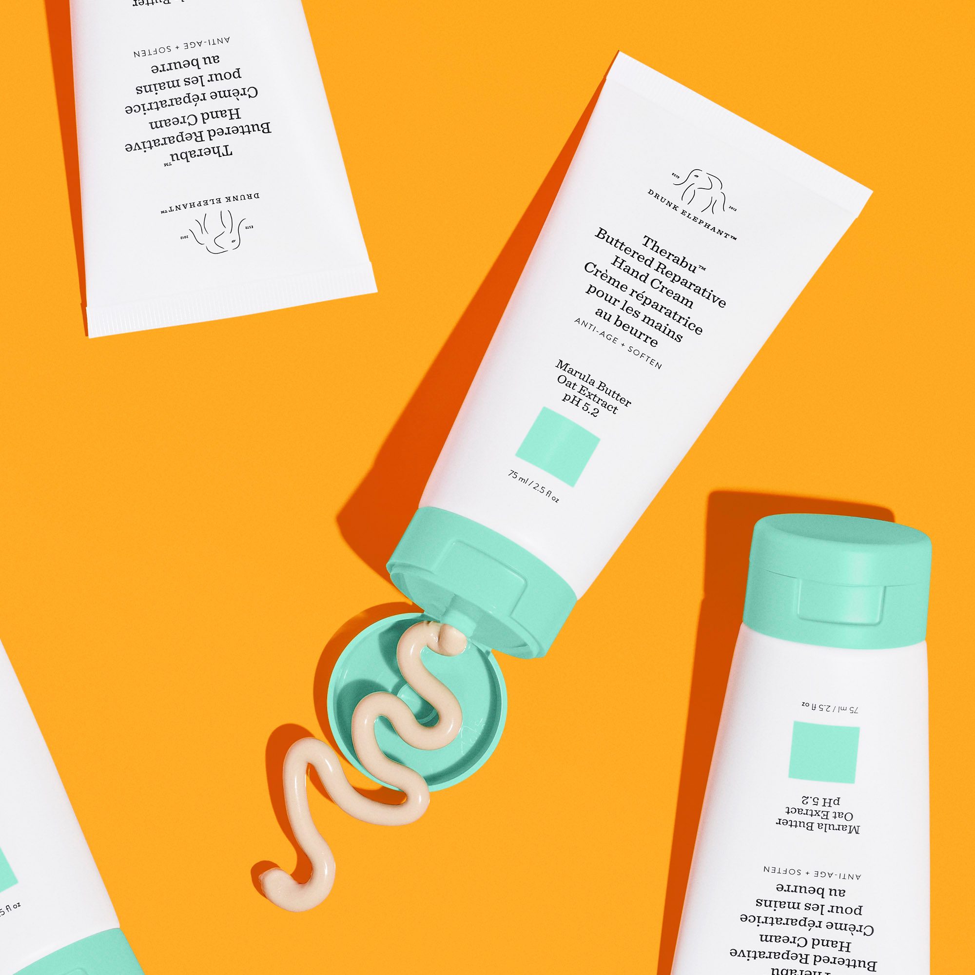 Drunk Elephant Therabu Hand Cream on Orange Background