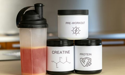 creatine three tubs protein pre workout shake drink on table