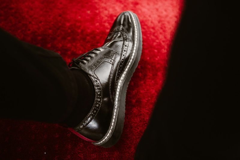person wearing black brogue shoe