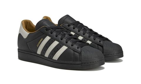 side view of black leather adidas superstar sneakers