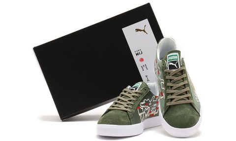 two green sneakers in front of black shoe box