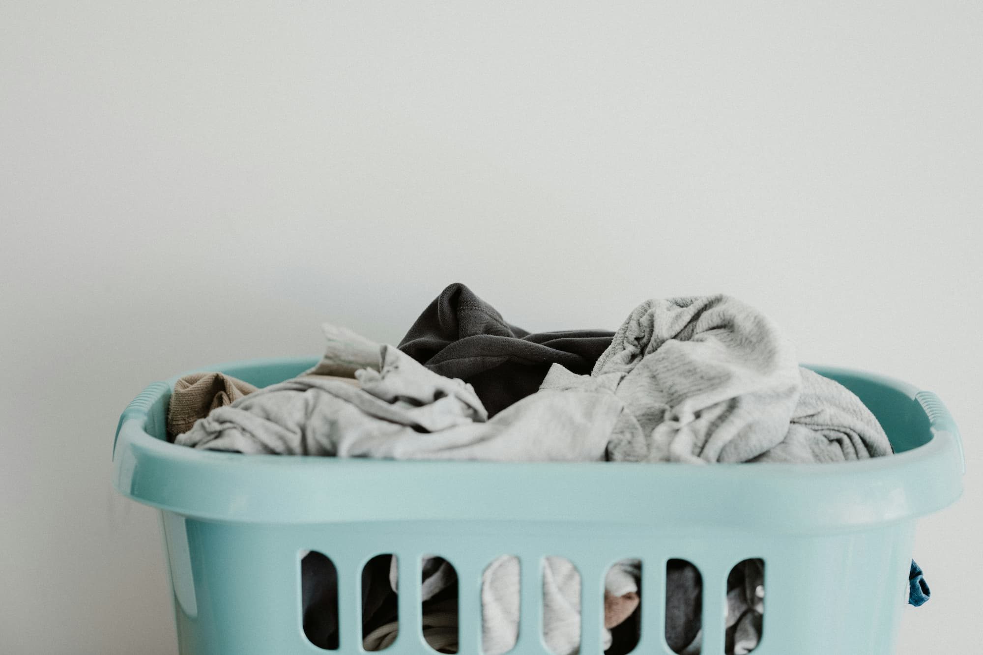 dirty laundry in a blue basket