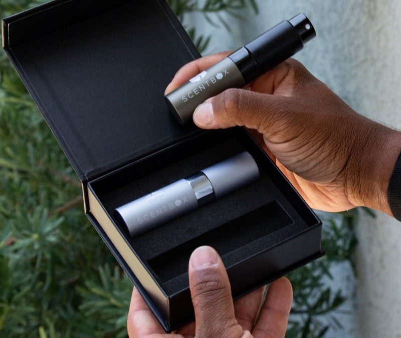 A man holding a cologne atomizer from Scentbox -- best grooming gifts