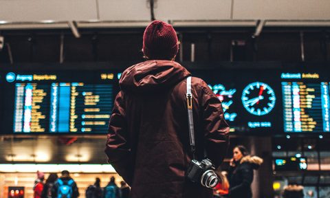 man looking at flight schedule in airport