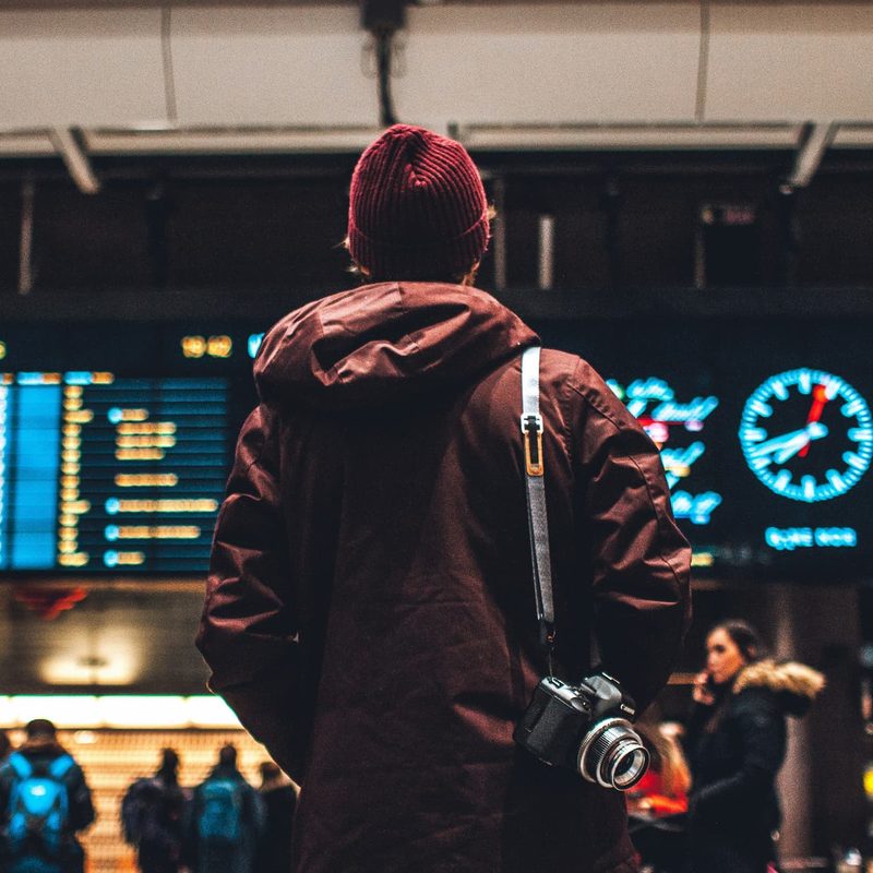man looking at flight schedule in airport