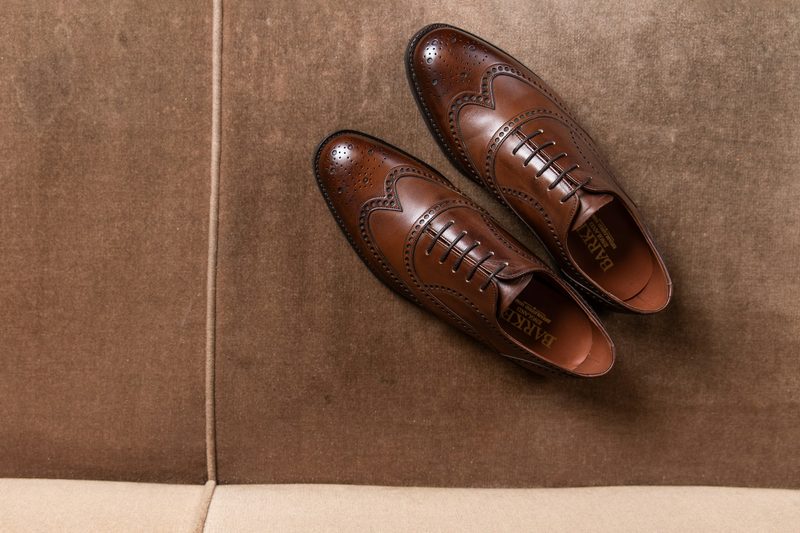 brown oxford wingtip shoes on floor