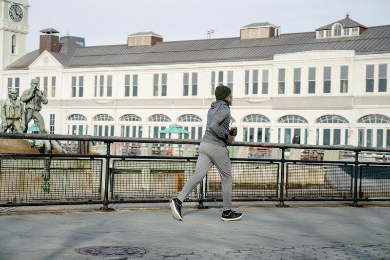 marathon and man running outside big building in cit