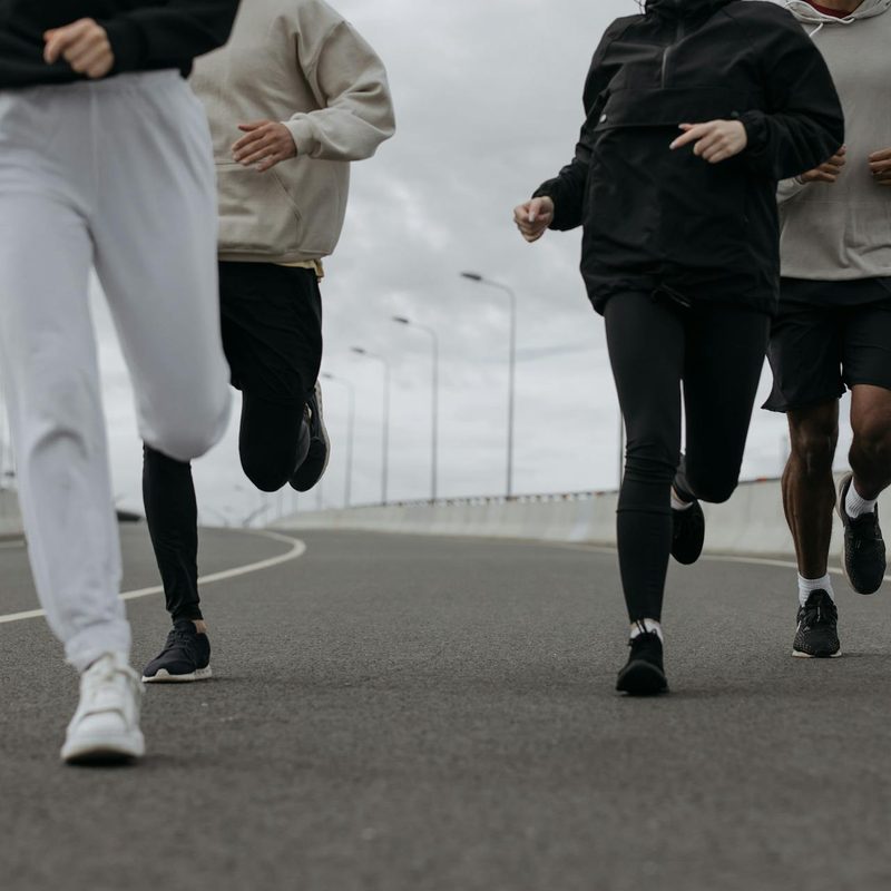 people group running together outside on road