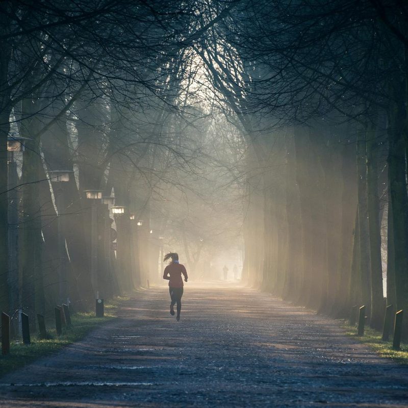 Woman running between trees