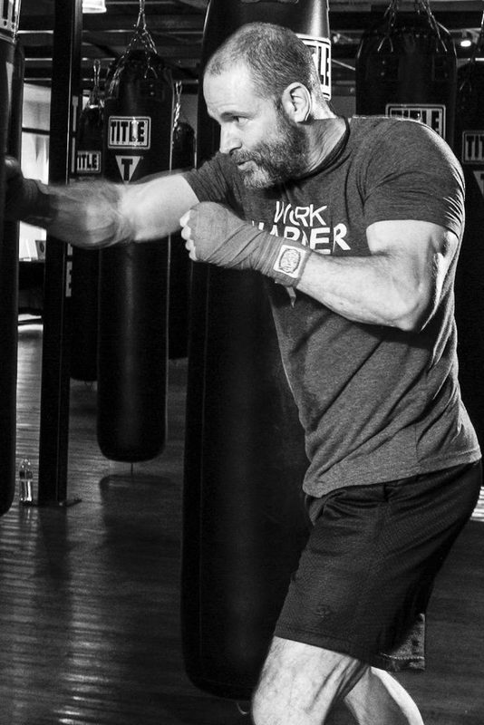 man boxing in gym with punching bag