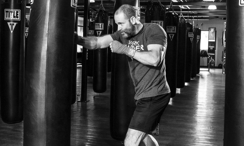 man boxing in gym with punching bag