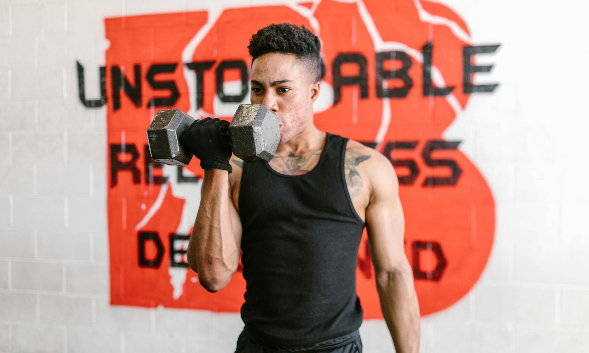 -man doing one arm unilateral bicep curl dumbbel