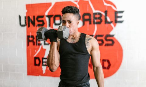 -man doing one arm unilateral bicep curl dumbbel
