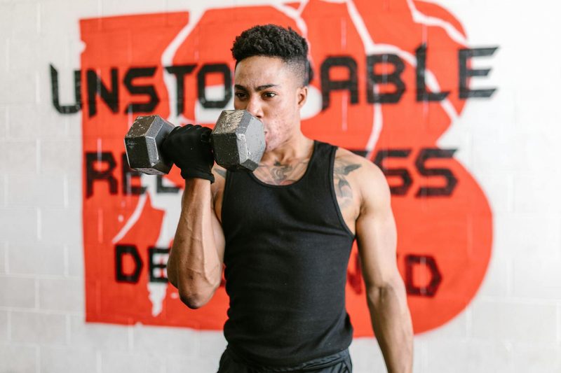 -man doing one arm unilateral bicep curl dumbbel