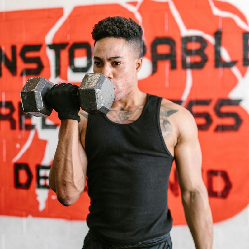 -man doing one arm unilateral bicep curl dumbbel
