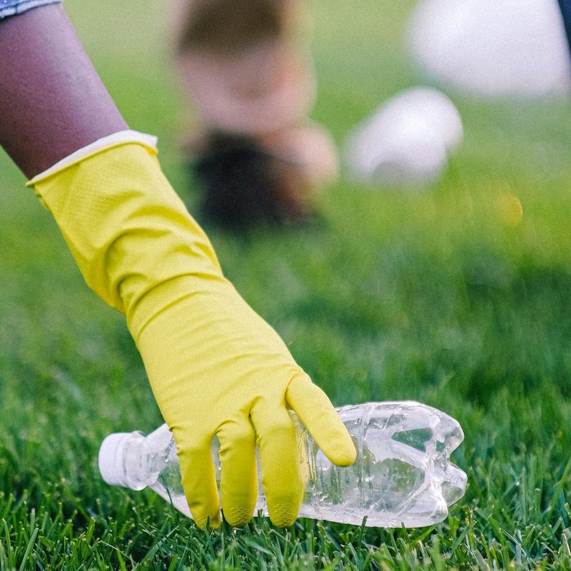 Picking up plastic water bottle wearing gloves