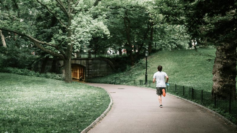 Man running jogging outdoors outside in nature on a path