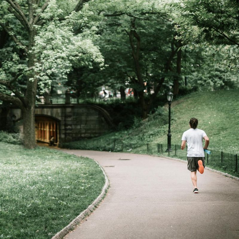 Man running jogging outdoors outside in nature on a path