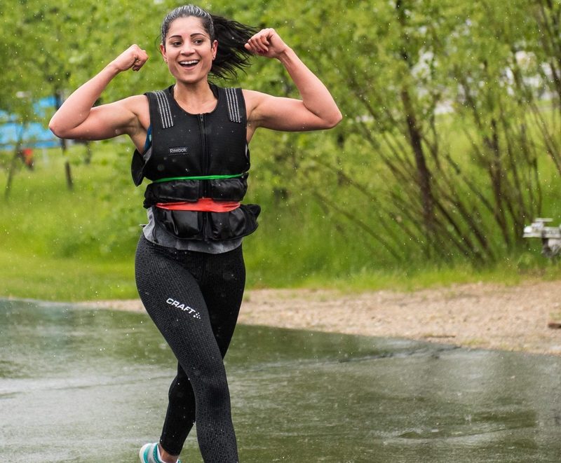 woman wearing weighted vest happy walking working out outdoors