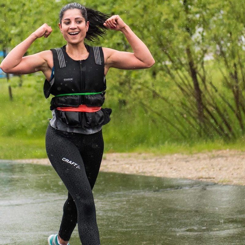 woman wearing weighted vest happy walking working out outdoors