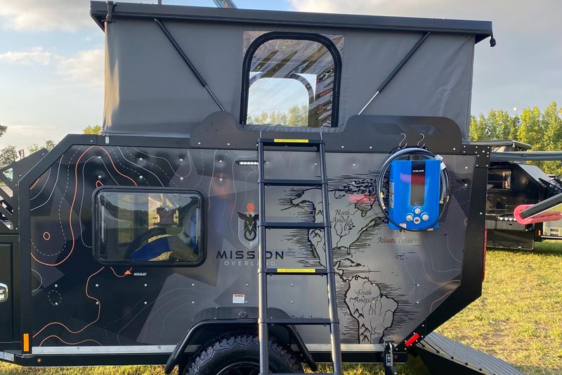 Side view of the rooftop tent on Mission Overland's Trail Dog toy hauler camper trailer.