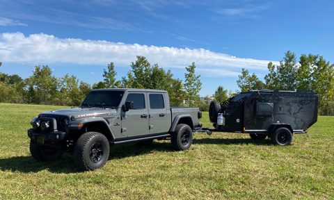 Mission Overland Trail Dog powersports camper trailer parked in a grassy field.